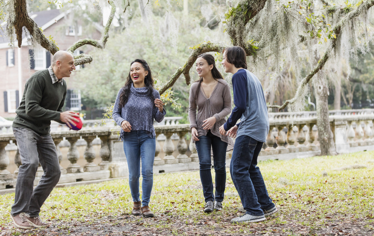 A multiracial family taking a walk in the park to celebrate Father's Day